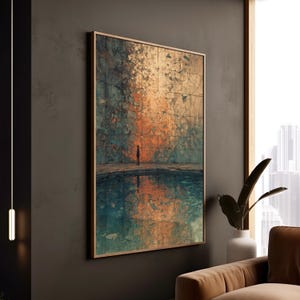 Op de afbeelding: Een ingelijste abstracte kunstprint. Het kunstwerk toont een eenzaam figuur voor een reflecterend water, met een getextureerde muur in tinten oranje, blauwgroen en bruin. Het kunstwerk wordt getoond in een kamer met een raam en een bruine bank.