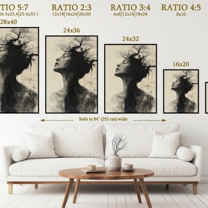 a living room with a white couch and three paintings on the wall