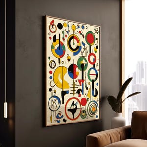 May include: Abstract art print featuring a vibrant composition of geometric shapes in red, yellow, blue, and green against a cream background. The artwork is framed in a wooden frame and hangs on a dark gray wall.
