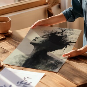 a person holding a picture of a woman's face on a table