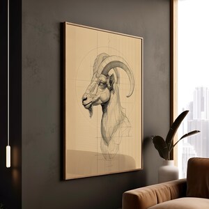 May include: A framed art print featuring a detailed pencil sketch of a goat's head and neck. The artwork is set against a tan background with geometric lines, and is displayed in a room with a modern aesthetic.
