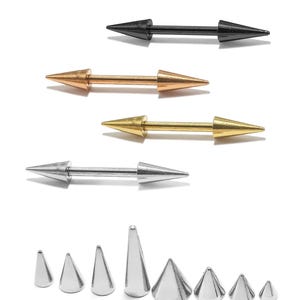 Op de afbeelding: Een assortiment lichaamsjuwelen, waaronder barbells en conisch gevormde studs. De barbells zijn in zwart, koper, goud en zilver. De studs zijn zilver en variëren in grootte, allemaal met een kegelvorm. De achtergrond is wit.