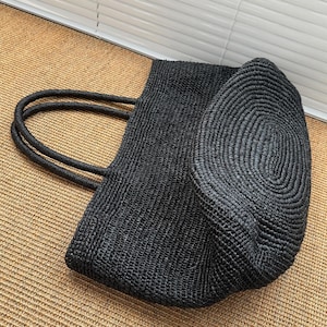 Pode incluir: Uma caneca de cer&acirc;mica branca com uma al&ccedil;a preta e o texto "But First, Coffee" em preto, em negrito. A caneca tem aproximadamente 10 cm de altura e comporta cerca de 350 ml de l&iacute;quido.