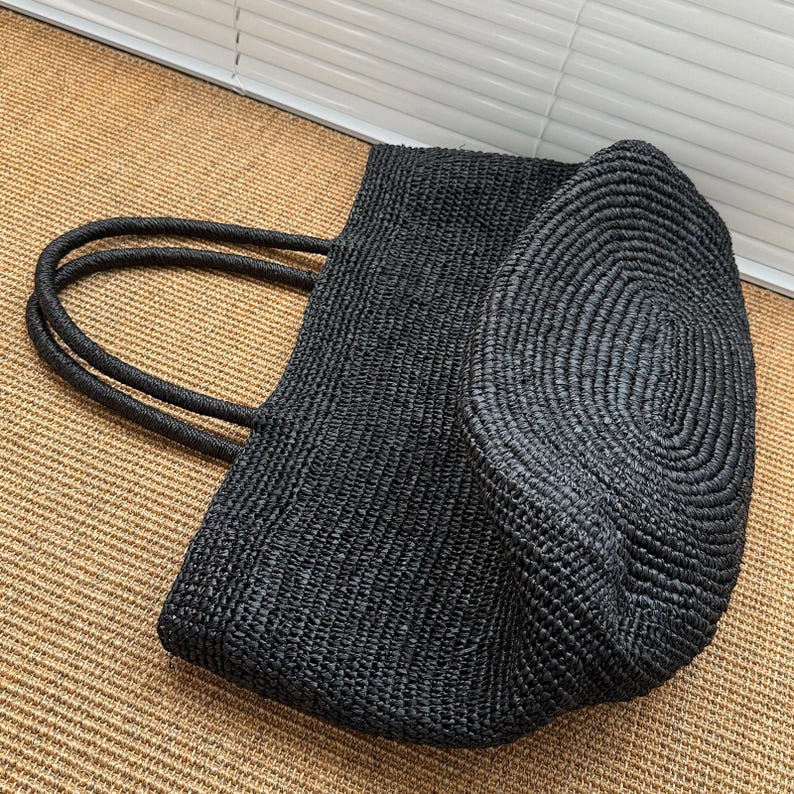 Pode incluir: Uma caneca de cer&acirc;mica branca com uma al&ccedil;a preta e o texto "But First, Coffee" em preto, em negrito. A caneca tem aproximadamente 10 cm de altura e comporta cerca de 350 ml de l&iacute;quido.