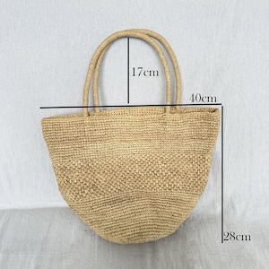 May include: A beige woven tote bag with two handles. The bag measures 40cm wide, 28cm tall, and the handles are 17cm high. The bag is made from a natural fibre material.