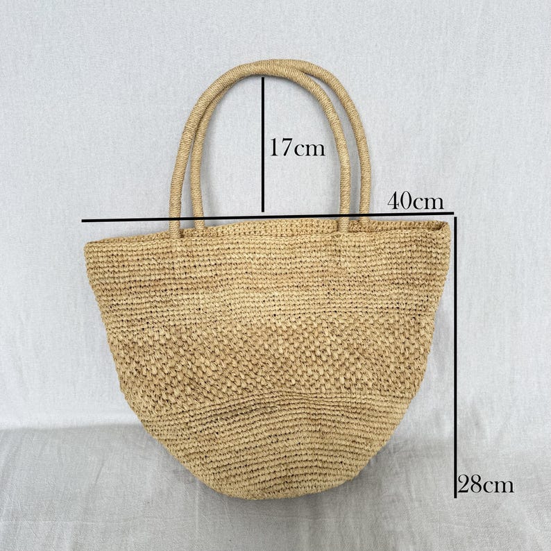 May include: A beige woven tote bag with two handles. The bag measures 40cm wide, 28cm tall, and the handles are 17cm high. The bag is made from a natural fibre material.