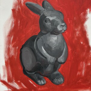 May include: A grayscale painting of a rabbit figurine against a red background. The rabbit is depicted in a seated position, with its ears perked up. The artwork is painted on canvas, with visible brushstrokes.