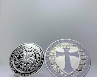 Könnte beinhalten: Zwei silberne Münzen mit detaillierten Designs. Eine Münze zeigt einen Ritter zu Pferd, umgeben von Text. Die andere Münze zeigt ein Kreuz auf einem Schild, mit Text am Rand. Beide Münzen haben ein geprägtes Aussehen.