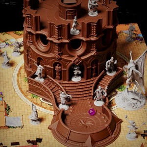 May include: A brown, multi-level miniature gaming tower structure featuring arched doorways, staircases, and circular windows. Several small, unpainted character figurines are positioned on the structure and the surrounding game board.
