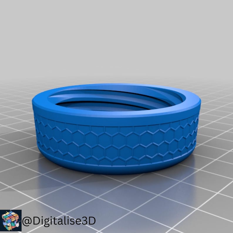May include: A blue, circular object with a honeycomb pattern around the side. The object has a recessed top and appears to be 3D-printed. The item is sitting on a grid-patterned surface. The text "@Digitalise3D" is in the lower left corner.