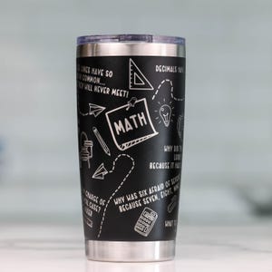 May include: A black stainless steel tumbler with a white design featuring math-related puns and doodles. The tumbler has a lid and a silver bottom. The text on the tumbler reads: "Parallel lines have so much in common...  Sadly they will never meet!"  "Decimals have a point."  "Why did the math book look sad? Because it had too many problems."  "Why was six afraid of seven? Because seven eight nine!"