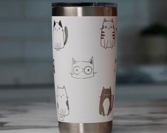 May include: A white stainless steel tumbler featuring a repeating pattern of various black and gray line-art cat illustrations. The design includes cats with different expressions, one wearing round glasses, and a metallic rim and base.