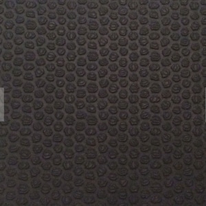 May include: Close-up of a dark grey textured surface. The surface features a repeating pattern of small, raised, rounded shapes, creating a bumpy texture. The pattern is consistent across the entire surface.