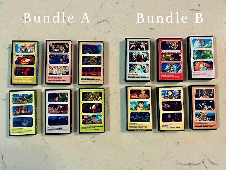 May include: Two bundles of collectible VHS tapes, labelled "Bundle A" and "Bundle B". Each tape features colourful artwork from animated films. The tapes are rectangular with black borders and are arranged on a light-coloured surface.