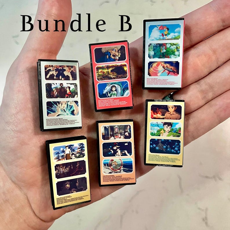 May include: A collection of miniature anime-themed art pieces, each with a black frame and colourful illustrations. The text "Bundle B" is at the top. The pieces feature various scenes and characters from anime.