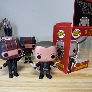 May include: Three Funko Pop figures of a character called "Clancy Paladin Strait" from the video game "The Binding of Isaac: Repentance". The figures are in a black and red box with the game's logo and the character's name. The box also has the text "I would swim to the bottom of the ocean for a Paladin Strait without a floatation device."