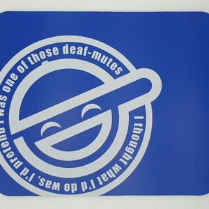 May include: A blue mouse mat with a white circle containing a smiling face and the text "I'd pretend I was one of those deaf-mutes I thought what I'd do was."