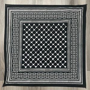 May include: Square black and white scarf with a geometric pattern. The scarf features a central diamond grid design, framed by borders of alternating stripes and wave-like patterns. The scarf is made of a soft material and is suitable for various uses.