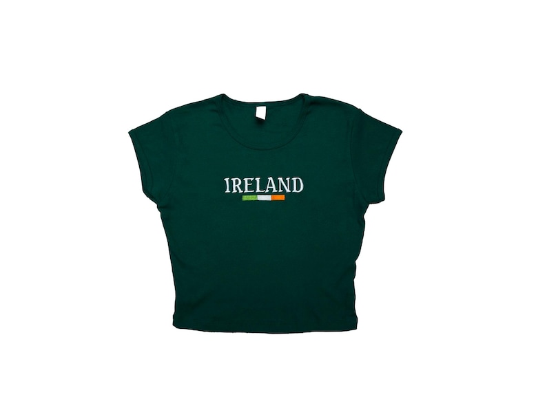 May include: A dark green cropped t-shirt with short sleeves and the word "IRELAND" in white lettering with the Irish flag underneath.