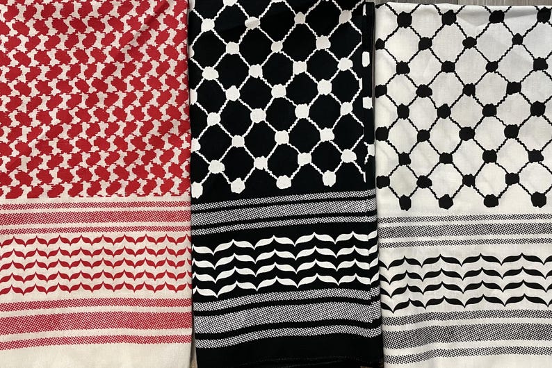 May include: Three keffiyeh scarves in red and white, black and white, and white and black. Each scarf features a distinct pattern, including a repeating geometric design and a border with a leaf-like motif. The scarves are folded and displayed side by side.