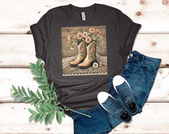 Camiseta gráfica con botas de vaquero rústicas y flores silvestres, raíces sureñas, diseño floral campestre, ropa vintage del oeste.