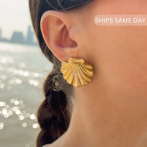 May include: Gold-toned shell-shaped earrings. The earrings are a classic design and would be a great addition to any jewelry collection.