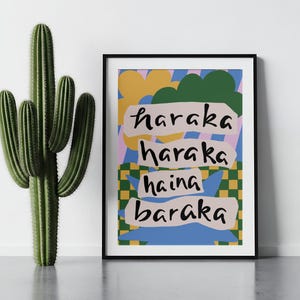 Könnte beinhalten: Ein gerahmter, rechteckiger Wandkunstdruck mit einem farbenfrohen Grafikdesign aus gelben Blumen, grünen Wolken und einem gelb-grünen Karomuster. Der Text "haraka haraka haina baraka" ist in Schwarz auf vier hellrosa horizontalen Streifen gedruckt.