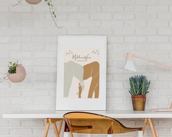May include: A white framed print with a minimalist design featuring two elephants in shades of brown and gray, with the text "Mdale na Wewe" and "Stronger With You" in a brown font. The print is hanging on a white brick wall.