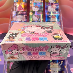 Coffret Sanrio Booster de 32 Paquets de Cartes Holographiques à Collectionner – Personnages iconiques et exclusifs pour les passionnés.