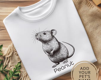 May include: White t-shirt with a black and white illustration of a mouse. The text "Peanut" is printed below the mouse. The text "Add Your Pet's Name" is printed in a circle on the bottom right corner of the shirt.
