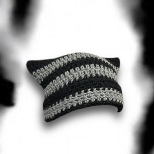 Pode incluir: Um gorro de malha listrado preto e cinza.