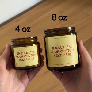 Peut inclure: Deux bougies en pot de verre ambr&eacute; avec des &eacute;tiquettes jaunes. Le petit pot est marqu&eacute; 4 oz et le grand pot est marqu&eacute; 8 oz. Les &eacute;tiquettes portent le texte : SMELLS LIKE YOUR CUSTOM TEXT HERE, DASH0 SHOP, MADE IN CALIFORNIA, COFFEE SHOP, 100% SOY WAX CANDLE.