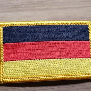 May include: A black, red, and yellow embroidered patch of the German flag.