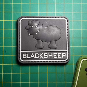 May include: Black and white embroidered patch featuring a cartoon black sheep and the text "BLACKSHEEP".