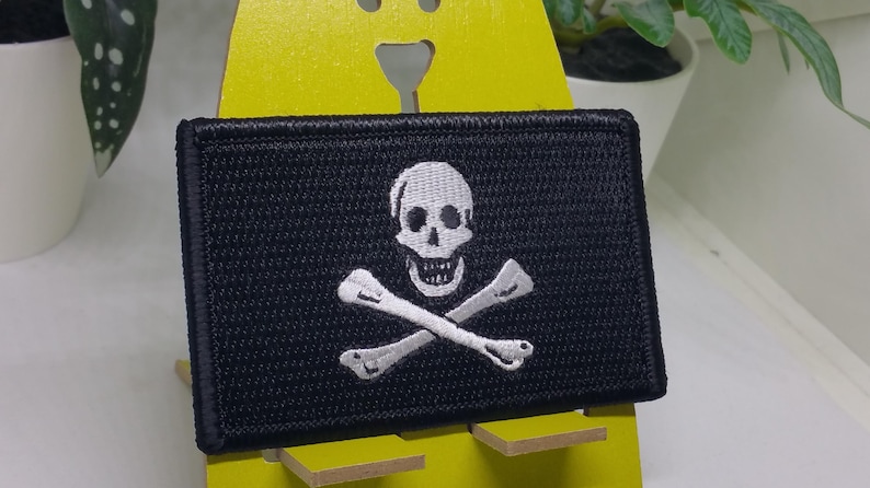 May include: A black embroidered patch with a white skull and crossbones design.