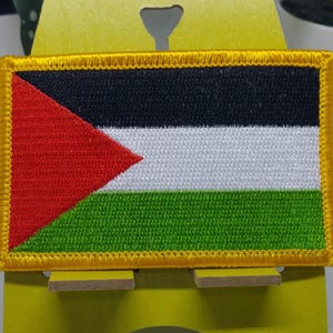 May include: A Palestinian flag patch with a red triangle, black, white, and green stripes, and a gold border.