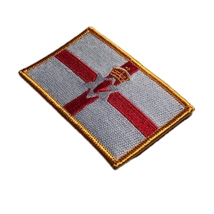 Puede incluir: Parche bordado con la bandera de Irlanda del Norte. El parche rectangular tiene un fondo gris claro con una cruz roja y una corona dorada. El borde es dorado.