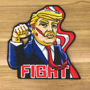 Toppa di lotta del presidente Donald Trump, morale, orecchio tattico, sangue, pugno chiuso, immagine iconica, campagna, tentativo di assassinio, ricamo