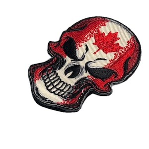 May include: Embroidered patch in the shape of a skull, featuring the Canadian flag design. The skull has a red outline and a red maple leaf on a white background. The eyes and nose are black.
