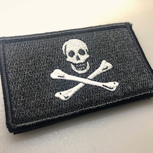 May include: A black embroidered patch with a white skull and crossbones design.