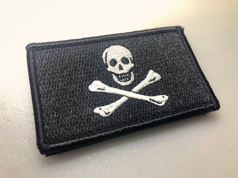 May include: A black embroidered patch with a white skull and crossbones design.