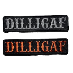 May include: Two rectangular patches with the word "DILLIGAF" embroidered in capital letters. One patch has gray lettering on a black background, and the other has orange lettering on a black background.