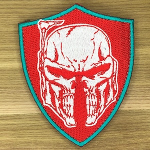 May include: Embroidered patch with a white skull design and red accents, set on a red shield with a teal border. This patch is a unique accessory for jackets, bags, or other fabric items.