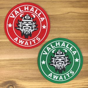 Op de afbeelding: Twee ronde geborduurde patches. Eén is rood met witte tekst en een Viking-afbeelding, met de tekst "VALHALLA AWAITS". De andere is groen met witte tekst en een Viking-afbeelding, eveneens met de tekst "VALHALLA AWAITS".