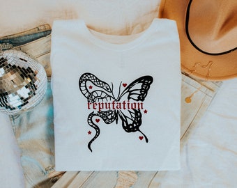 Schmetterling | Baumwoll T-Shirt T.S. Inspiriert | Handarbeit | Swiftie Merch ist in allen Größen erhältlich