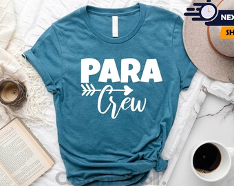 May include: A teal blue t-shirt with the text "PARA Crew" in white lettering. An arrow with a heart at the end is above the text.