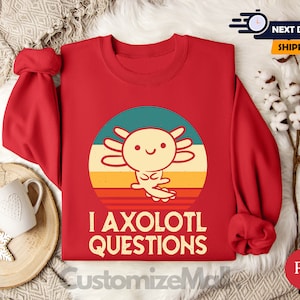 May include: Red sweatshirt featuring a retro-style graphic of an axolotl and the text "I axolotl questions".