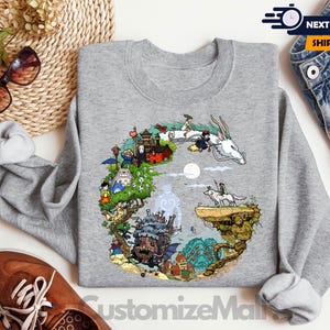 a gray sweatshirt with a colorful illustration of a castle, a dragon, and various other fantastical elements, along with a pair of jeans and sunglasses.