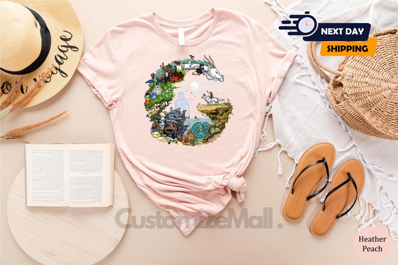 a pink t-shirt with a colorful graphic design, a straw hat, a book, a pair of sandals, and a woven basket, all arranged on a light-colored surface.