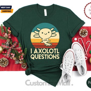 May include: A green t-shirt with a retro-style sunset graphic featuring an axolotl. The text "I axolotl questions" is printed below the graphic.